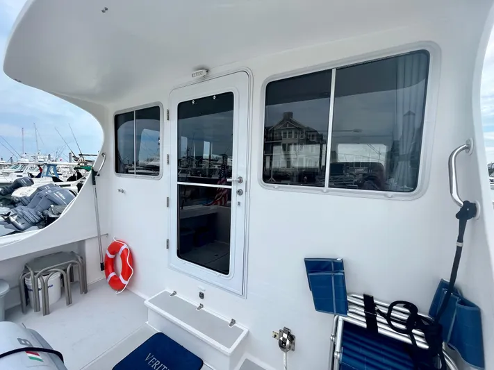 Veritas Yacht Photos Pics 2016 Wesmac 42 boat deck with seating, life preserver, and marina view.