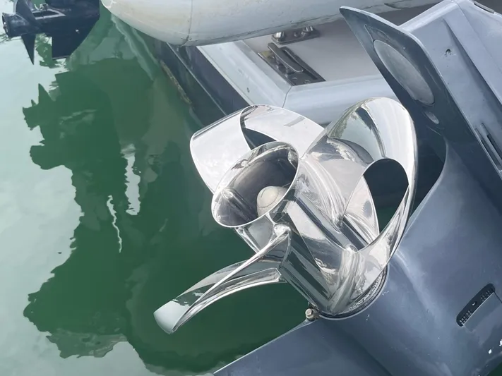 Veritas Yacht Photos Pics Shiny boat propeller on a 2016 Wesmac 42, docked by green water.