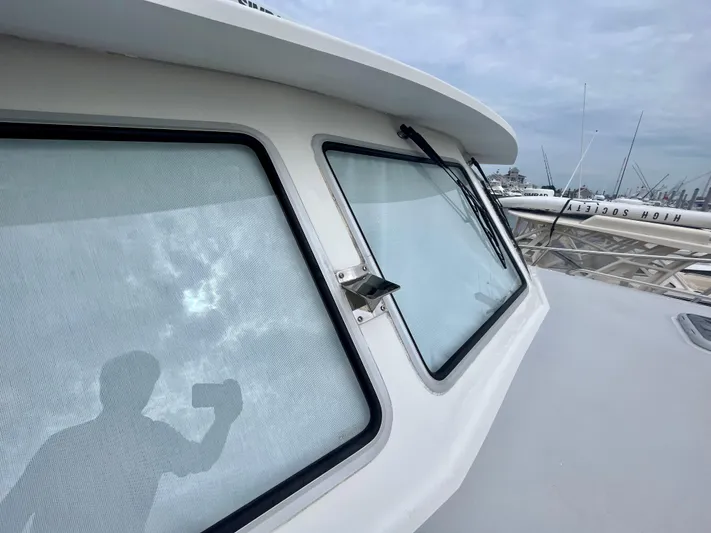 Veritas Yacht Photos Pics 2016 Wesmac 42 boat with large windows and docked fishing rods.