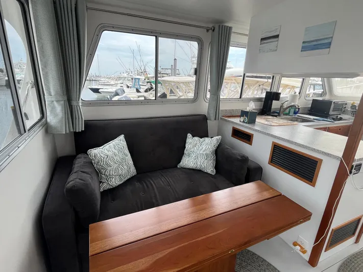 Veritas Yacht Photos Pics Cozy interior of 2016 Wesmac 42 boat with sofa and wooden table.