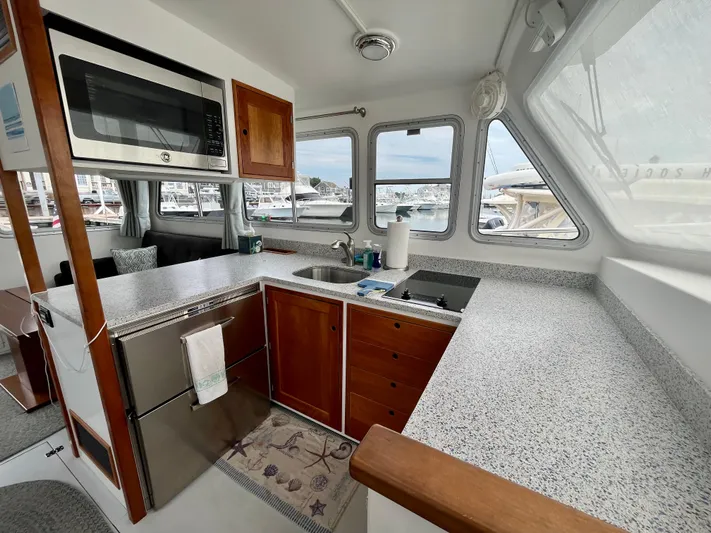 Veritas Yacht Photos Pics 2016 Wesmac 42 boat interior with modern kitchen, featuring wood cabinets and stainless steel appliances.