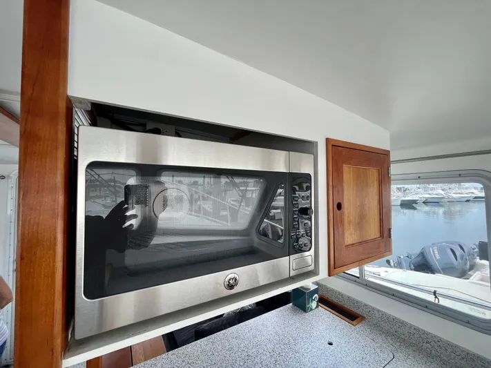 Veritas Yacht Photos Pics Microwave in 2016 Wesmac 42 boat kitchen with wooden cabinets and window view.