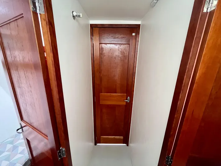 Veritas Yacht Photos Pics Wooden interior hallway of 2016 Wesmac 42 boat with closed door.