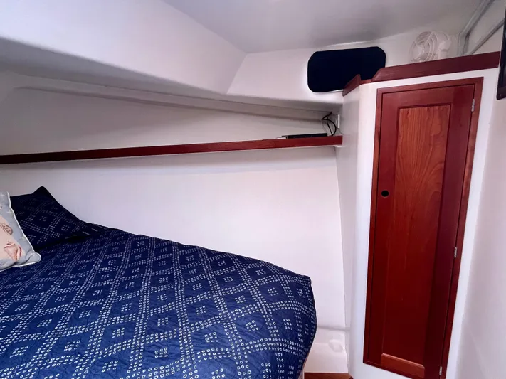 Veritas Yacht Photos Pics Cozy cabin interior of 2016 Wesmac 42 with blue bedding and wooden storage.