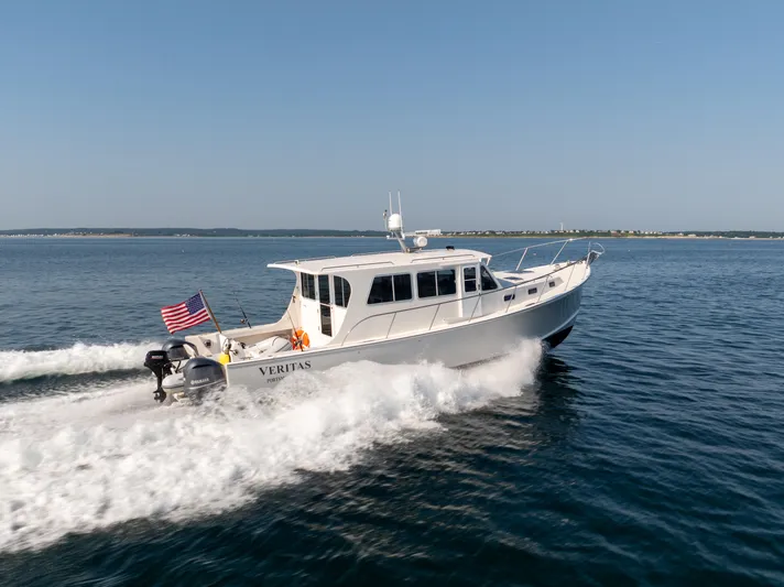 Veritas Yacht Photos Pics 2016 Wesmac 42 boat cruising on open water with American flag.