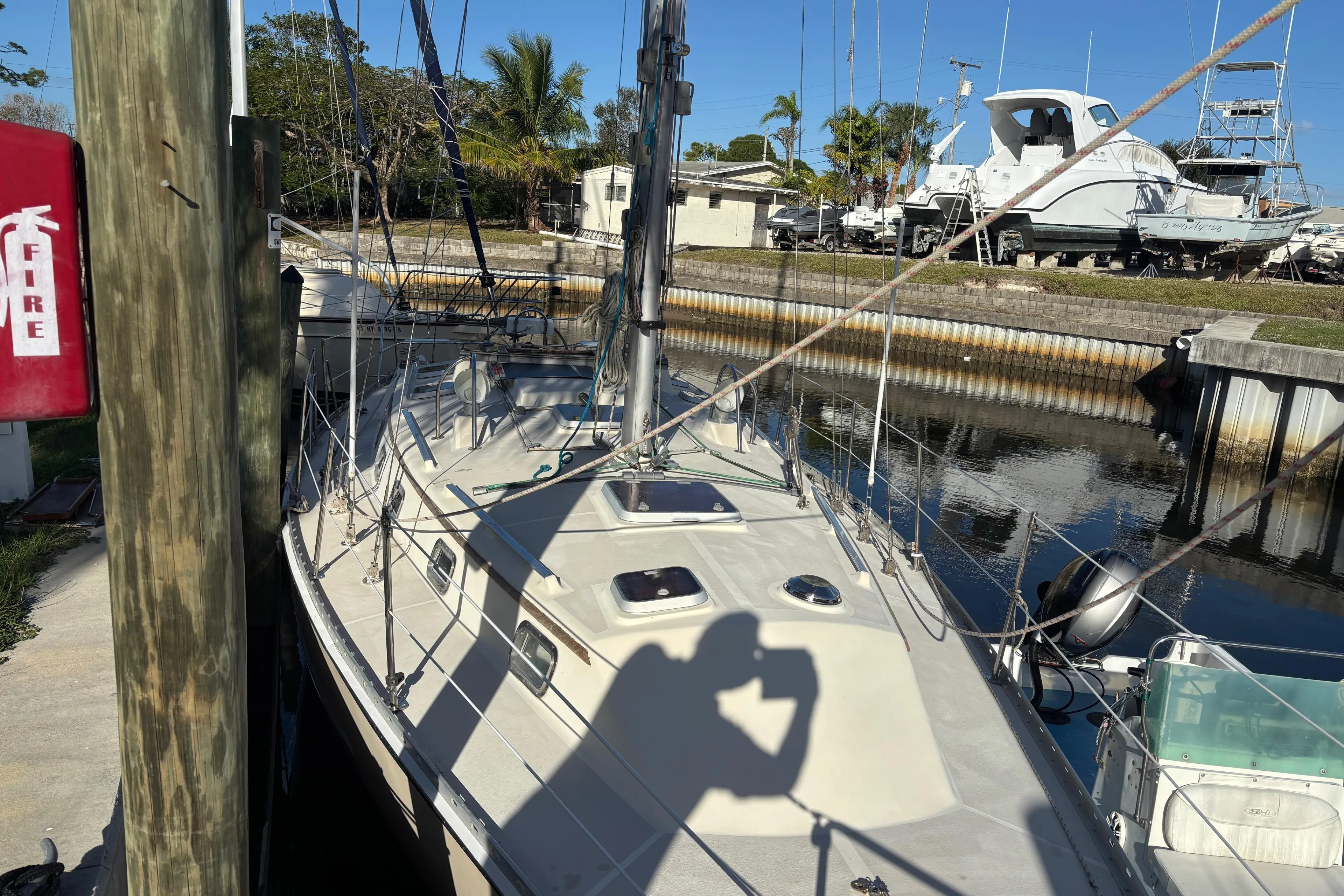 1997 Caliber 40LRC sailboat docked in marina, sunny day, palm trees in background.