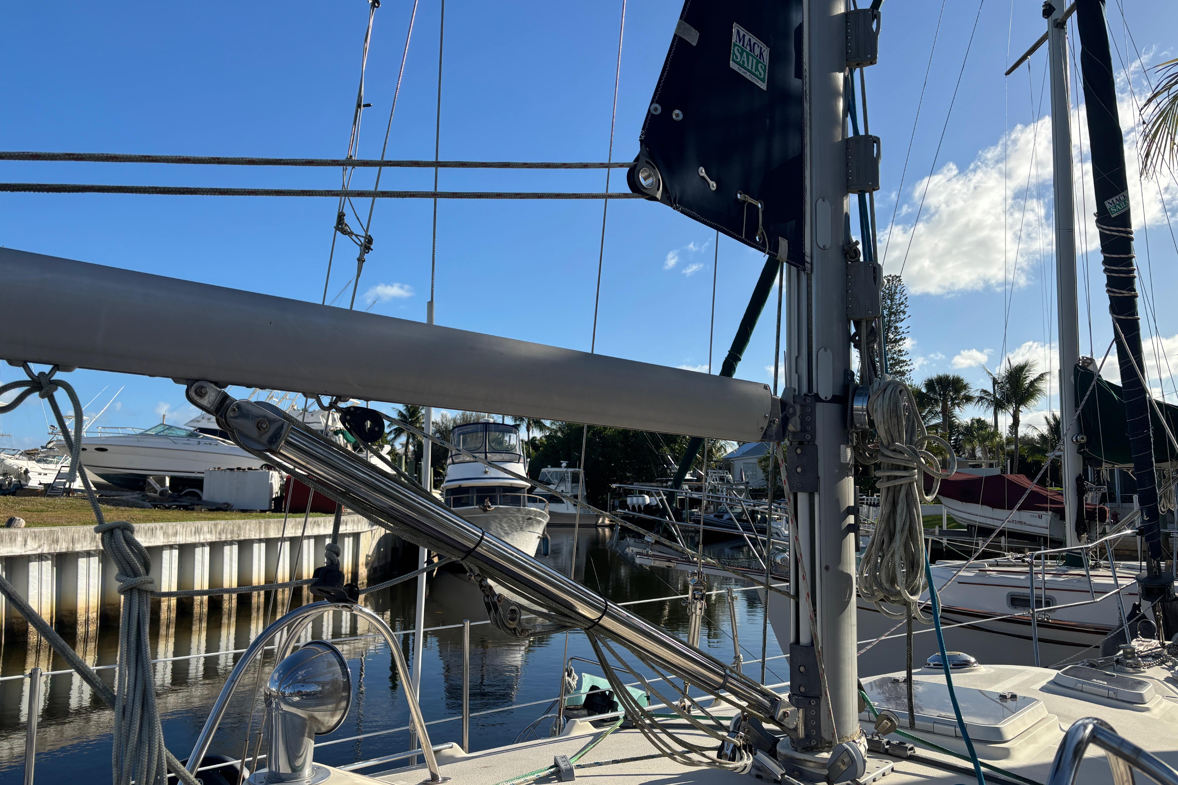 Sailboat deck view with rigging, Caliber 40LRC, 1997, docked in a marina under blue sky.
