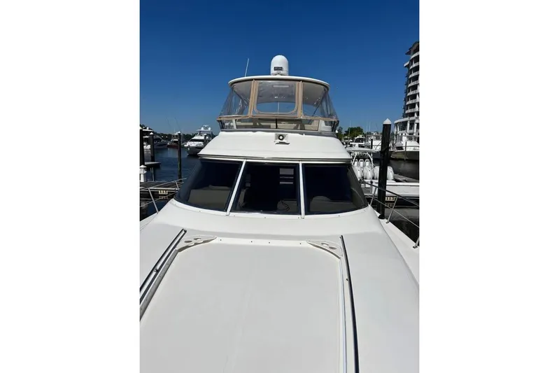  Yacht Photos Pics 2001 Sea Ray 480 Sedan Bridge yacht docked at marina under clear blue sky.
