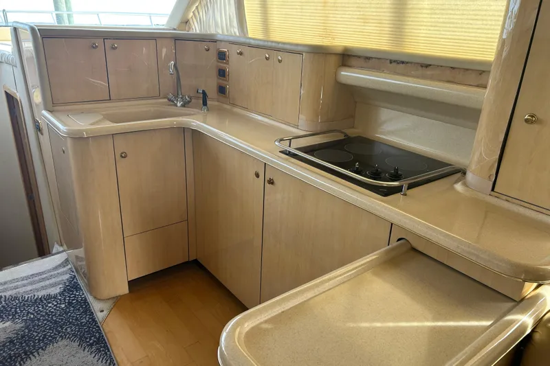  Yacht Photos Pics 2001 Sea Ray 480 Sedan Bridge yacht kitchen with light wood cabinetry and modern appliances.
