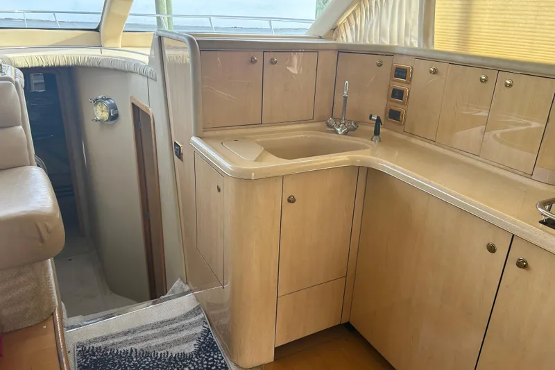  Yacht Photos Pics 2001 Sea Ray 480 Sedan Bridge yacht interior with wooden cabinetry and sink.