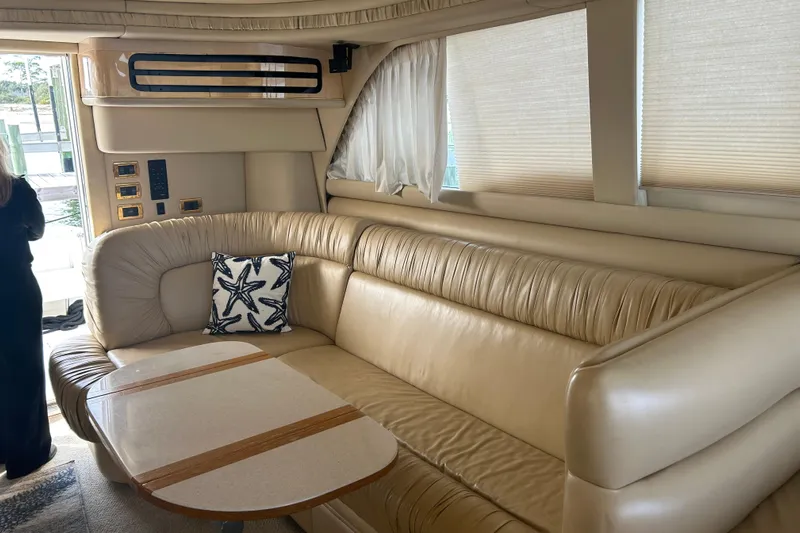  Yacht Photos Pics Luxurious interior of 2001 Sea Ray 480 Sedan Bridge with beige leather seating and starfish pillow.