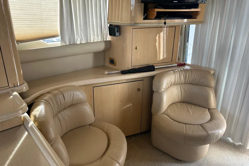  Yacht Photos Pics Luxurious interior of 2001 Sea Ray 480 Sedan Bridge with plush seating and elegant cabinetry.
