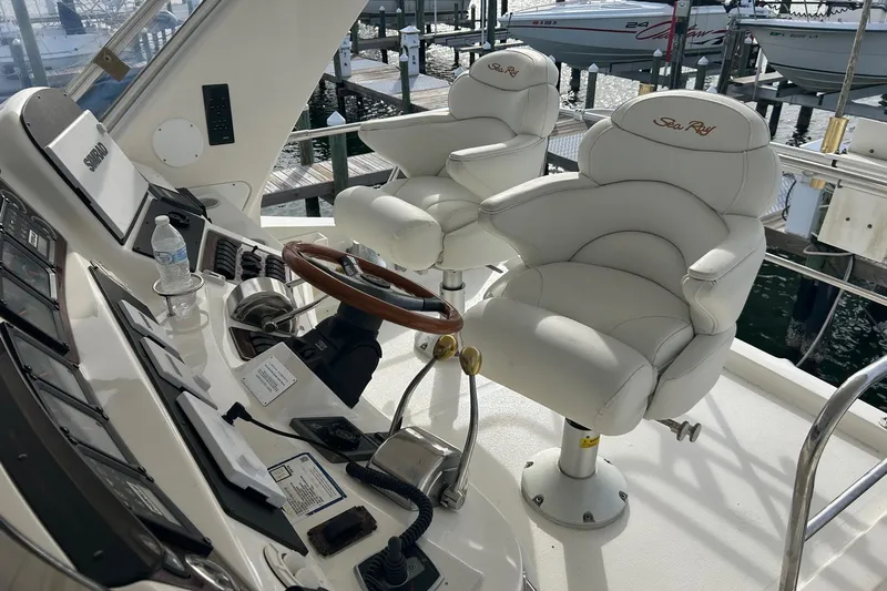  Yacht Photos Pics 2001 Sea Ray 480 Sedan Bridge helm with white captain chairs and control panel.