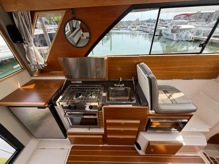  Yacht Photos Pics 2021 Cutwater C-32 C interior with kitchen, stove, sink, and marina view.