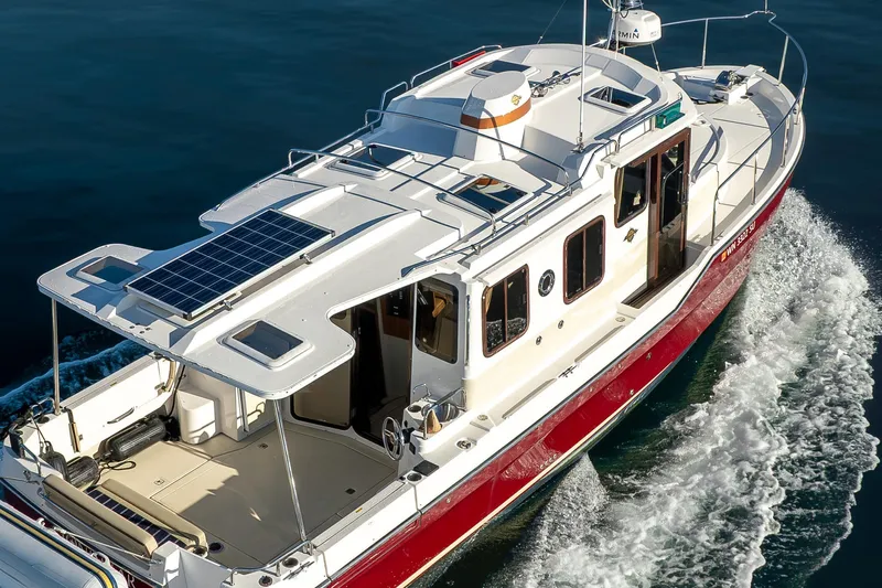 Lone Star Yacht Photos Pics 2022 Ranger Tugs R-31 S cruising on water, featuring solar panels on the roof.
