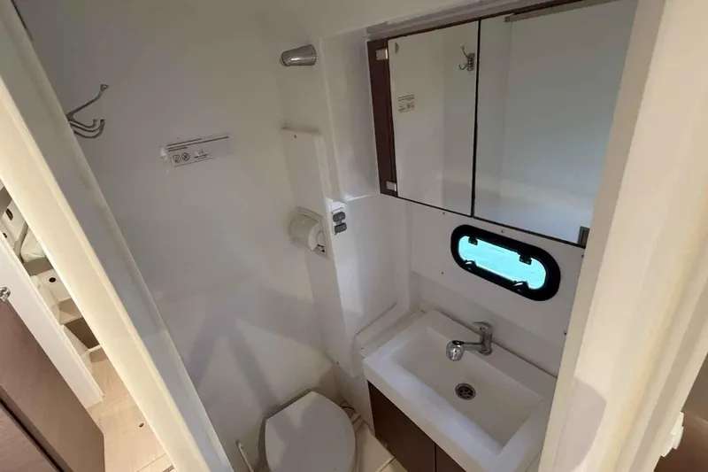 Raf IV Yacht Photos Pics Compact bathroom in 2020 Bali 4.3 model, featuring sink, mirror, and porthole window.