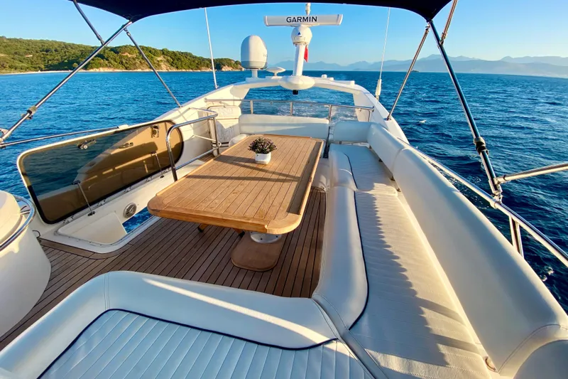  Yacht Photos Pics Luxurious 2004 Sunseeker Manhattan 56 yacht deck with seating and table, ocean view.