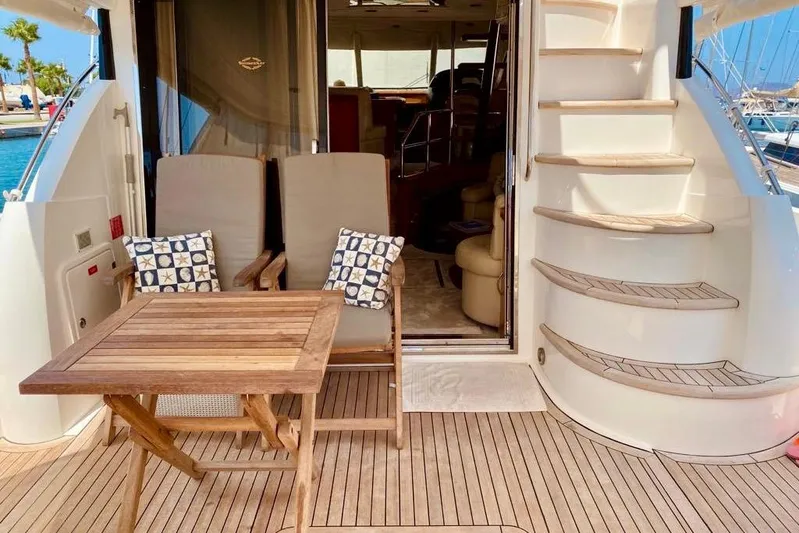  Yacht Photos Pics 2004 Sunseeker Manhattan 56 yacht deck with chairs, table, and spiral staircase.