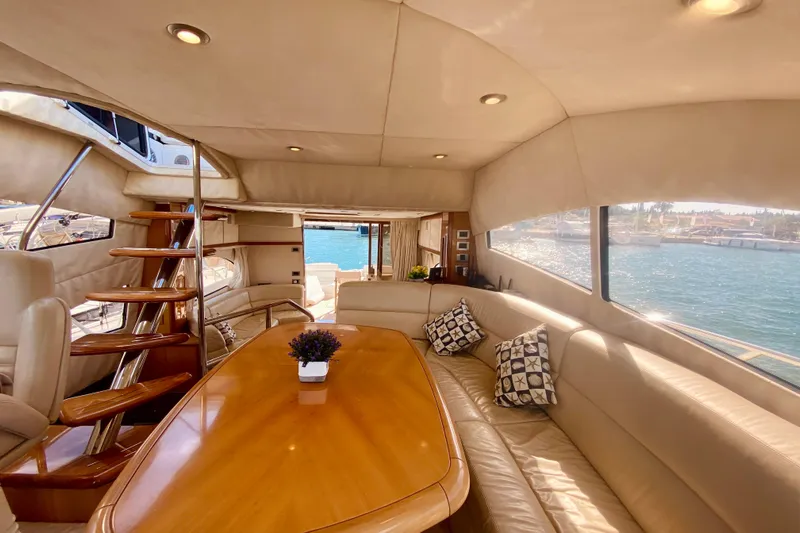  Yacht Photos Pics Luxurious interior of 2004 Sunseeker Manhattan 56 yacht with elegant seating and wooden table.