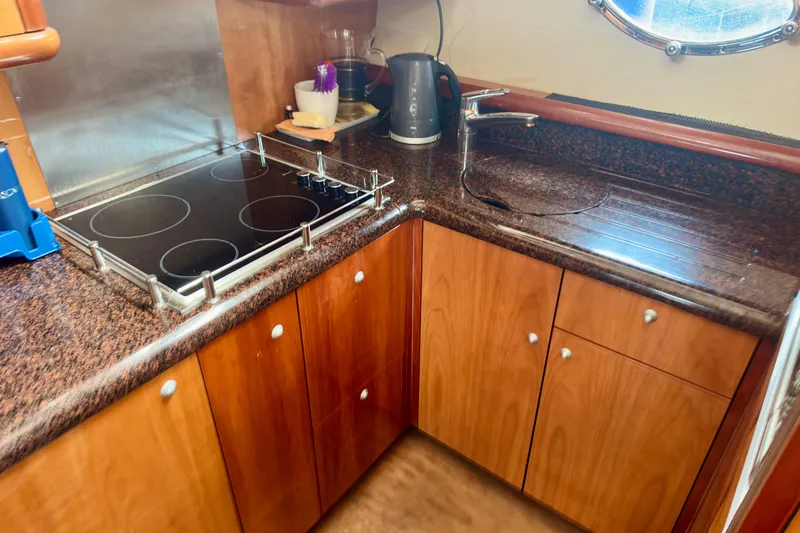  Yacht Photos Pics Luxurious kitchen in 2004 Sunseeker Manhattan 56 yacht with modern appliances and wood cabinetry.