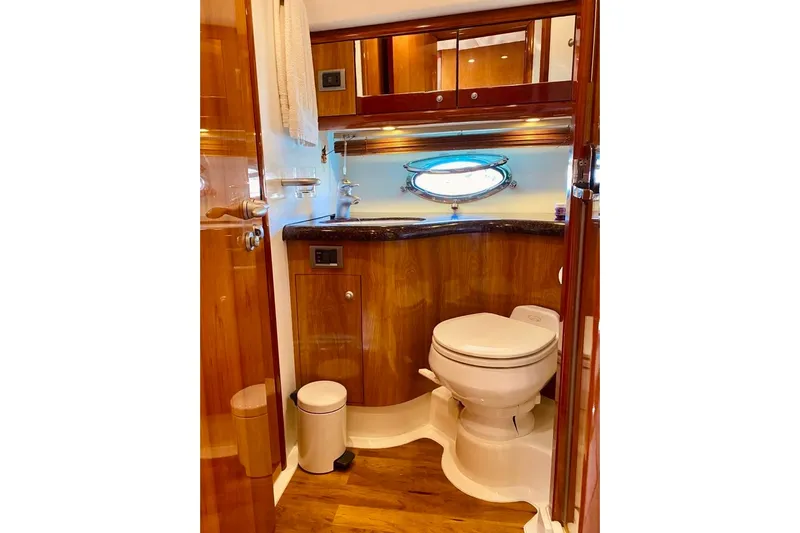  Yacht Photos Pics Luxurious bathroom in 2004 Sunseeker Manhattan 56 yacht with wooden cabinetry and porthole window.