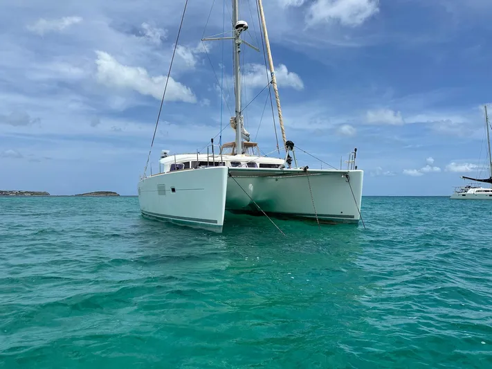  Yacht Photos Pics 2014 Lagoon 400 S2 catamaran anchored in clear turquoise waters under a blue sky.