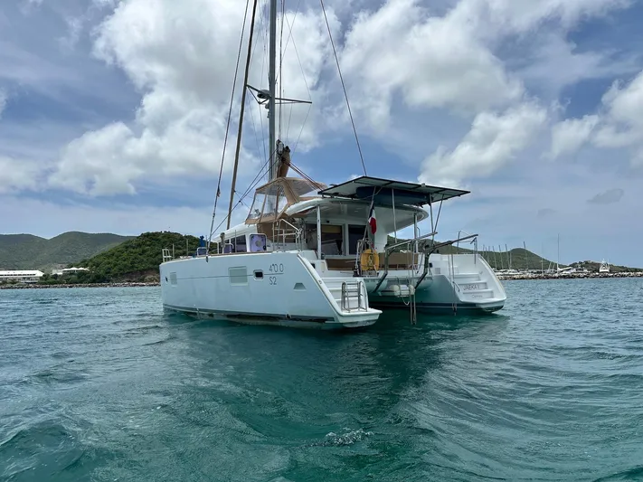  Yacht Photos Pics 2014 Lagoon 400 S2 catamaran sailing on clear blue waters under a cloudy sky.