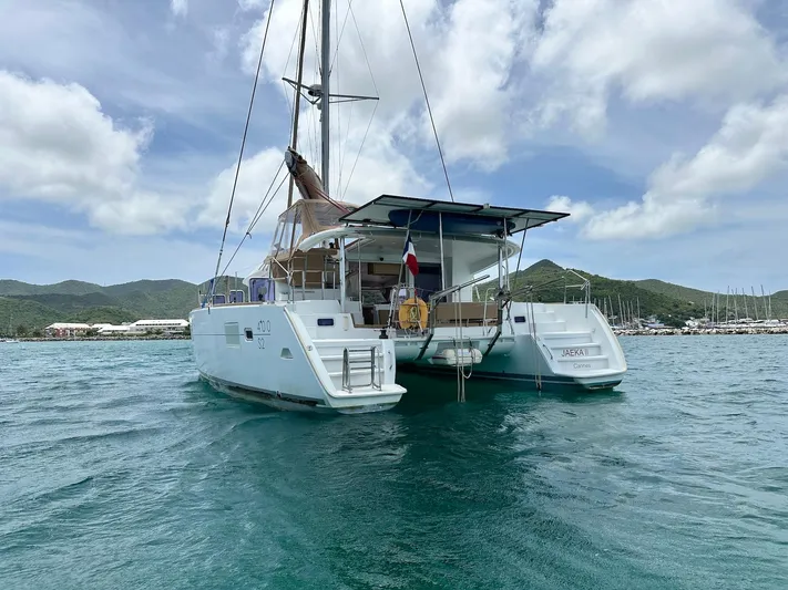  Yacht Photos Pics 2014 Lagoon 400 S2 catamaran on water, scenic backdrop, partly cloudy sky.