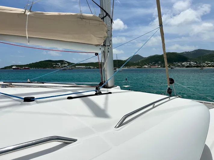  Yacht Photos Pics 2014 Lagoon 400 S2 catamaran sailing near scenic coastline under blue sky.