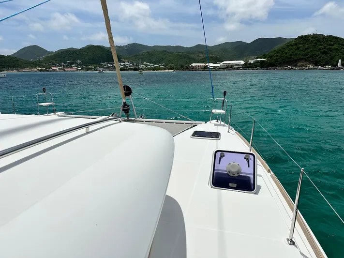  Yacht Photos Pics 2014 Lagoon 400 S2 catamaran sailing in turquoise waters with scenic mountain backdrop.