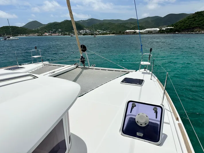  Yacht Photos Pics Lagoon 400 S2 catamaran sailing in turquoise waters, 2014 model, with scenic island backdrop.