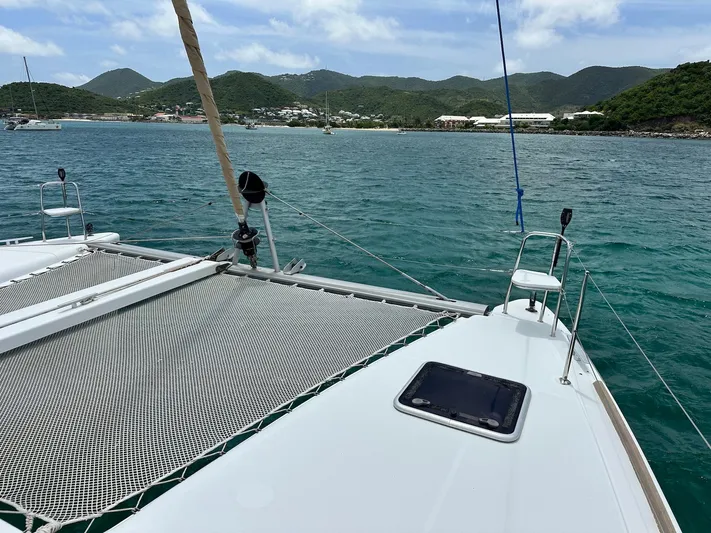  Yacht Photos Pics 2014 Lagoon 400 S2 catamaran sailing in turquoise waters near lush green hills.