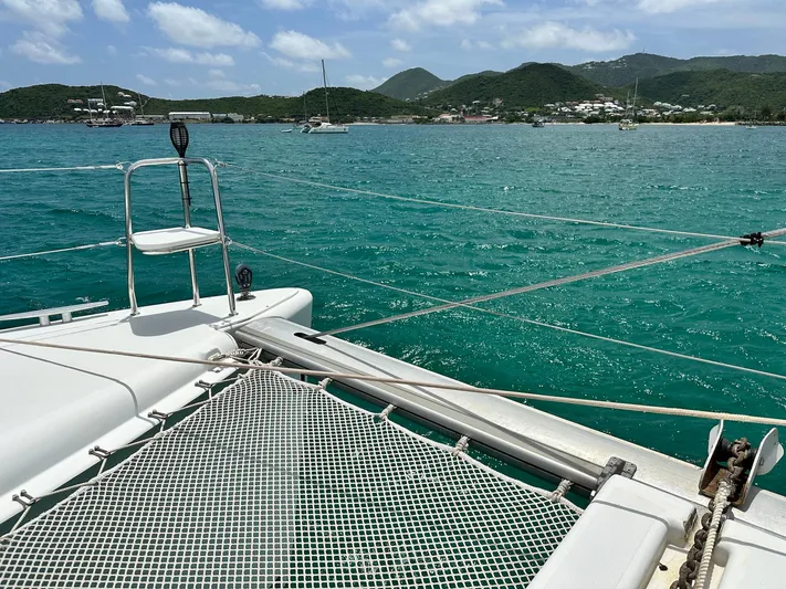  Yacht Photos Pics Lagoon 400 S2 catamaran on turquoise waters with scenic coastal backdrop.