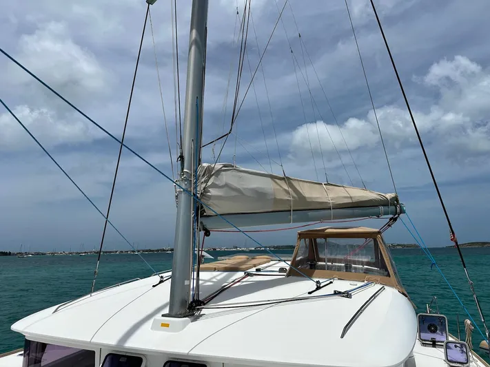  Yacht Photos Pics 2014 Lagoon 400 S2 catamaran with sails down, anchored in turquoise waters under cloudy sky.
