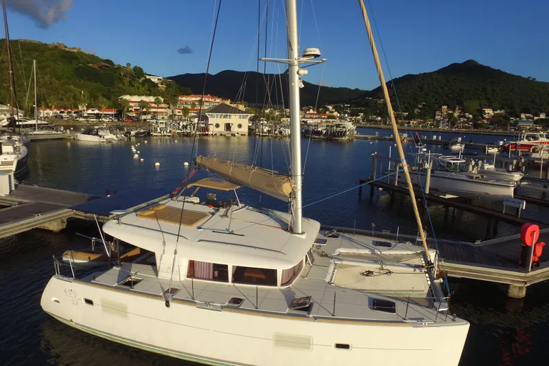  Yacht Photos Pics 2014 Lagoon 400 S2 catamaran docked in a scenic marina with lush hills.