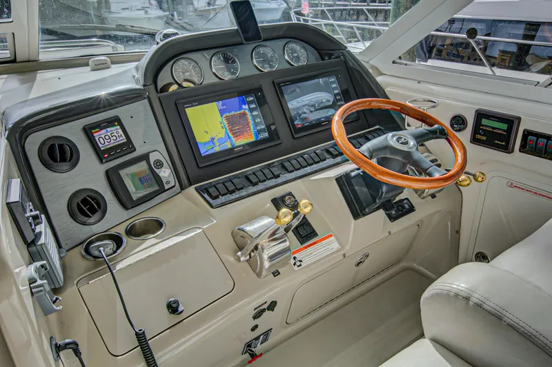 Bula Bula Yacht Photos Pics 2006 Sea Ray 40 Motor Yacht helm with navigation screens and wooden steering wheel.