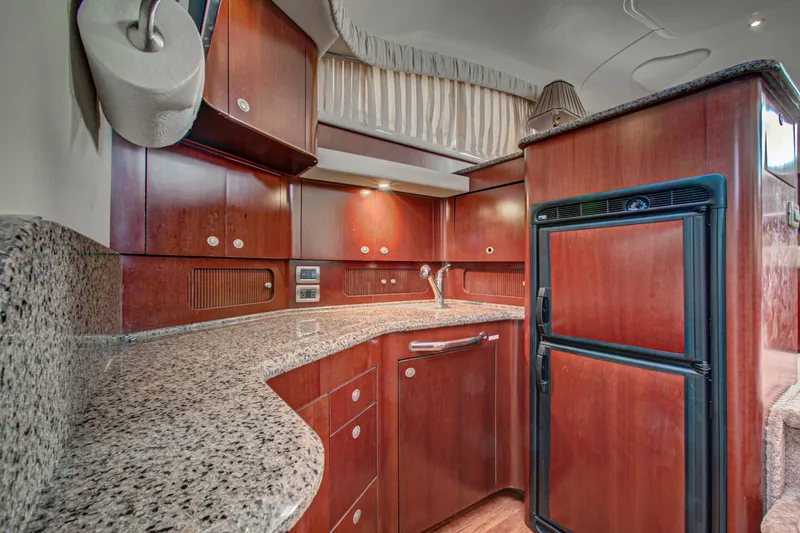 Bula Bula Yacht Photos Pics Luxurious kitchen interior of 2006 Sea Ray 40 Motor Yacht with wood cabinetry and granite countertops.