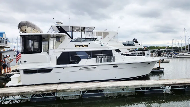 Now Or Never Yacht Photos Pics 1995 Carver 440 Aft Cabin Motor Yacht docked at marina under cloudy sky.