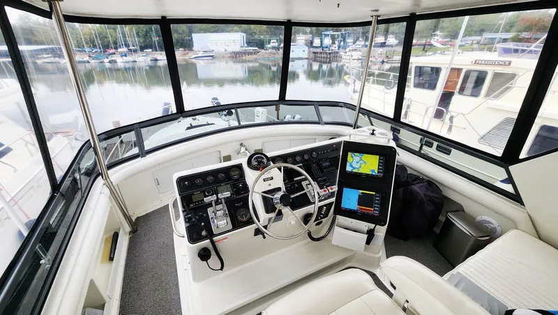 Now Or Never Yacht Photos Pics 1995 Carver 440 Aft Cabin Motor Yacht helm with navigation screens and marina view.