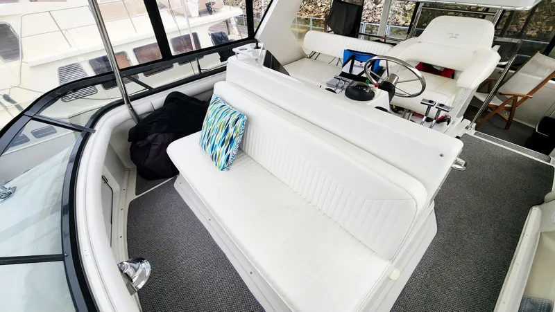 Now Or Never Yacht Photos Pics 1995 Carver 440 Aft Cabin Motor Yacht interior with white seating and colorful pillow.