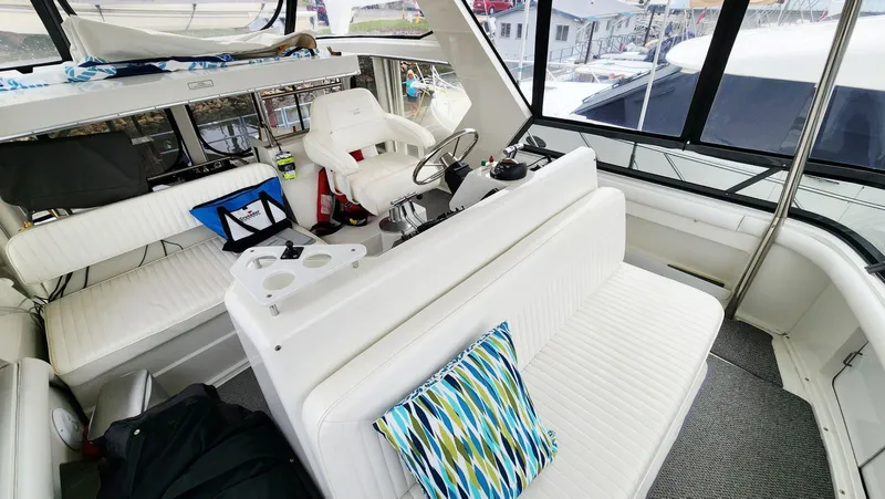 Now Or Never Yacht Photos Pics Interior of 1995 Carver 440 Aft Cabin Motor Yacht with white seating and colorful pillow.