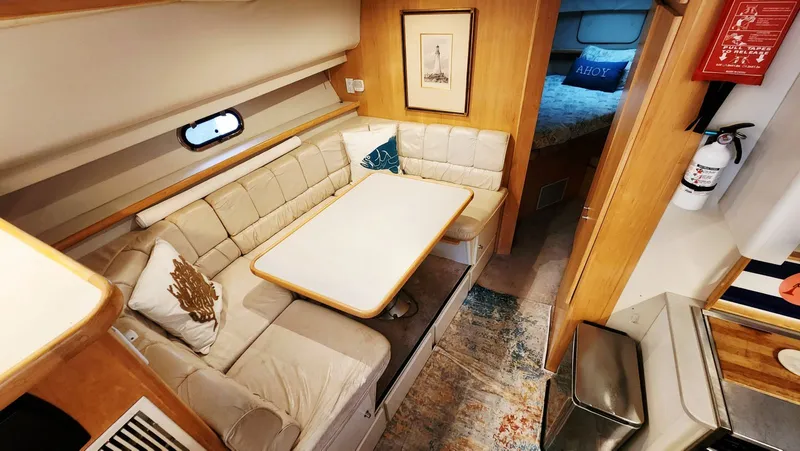 Now Or Never Yacht Photos Pics 1995 Carver 440 Aft Cabin Motor Yacht interior with cozy dining area and nautical decor.