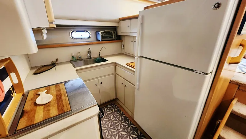 Now Or Never Yacht Photos Pics 1995 Carver 440 Aft Cabin Motor Yacht kitchen with white cabinets and appliances.