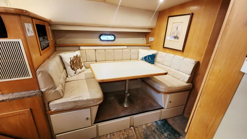 Now Or Never Yacht Photos Pics 1995 Carver 440 Aft Cabin Motor Yacht interior with cozy dining area and plush seating.