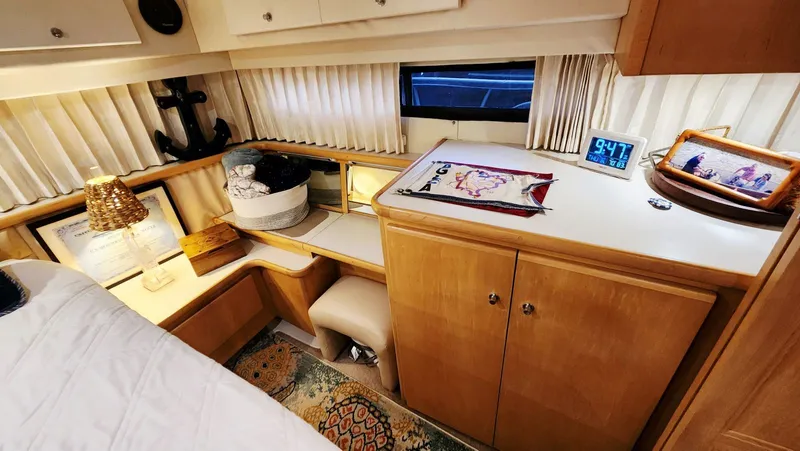 Now Or Never Yacht Photos Pics 1995 Carver 440 Aft Cabin Motor Yacht interior with cozy decor and wooden cabinetry.
