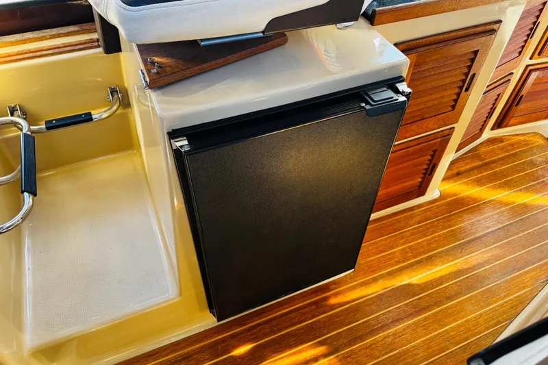 Walrus Yacht Photos Pics 2012 Ranger Tugs R-31 interior with wooden flooring and compact black refrigerator.