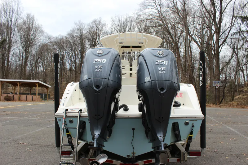  Yacht Photos Pics 2022 Cobia 280 Center Console with dual Yamaha 250 V6 engines in a wooded area.