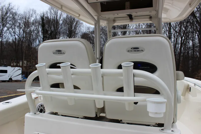  Yacht Photos Pics 2022 Cobia 280 Center Console boat seats with rod holders, parked outdoors.