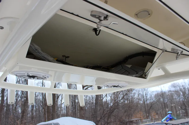  Yacht Photos Pics 2022 Cobia 280 Center Console boat storage compartment with rod holders and speakers.