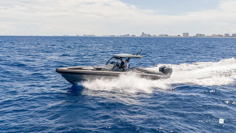 New 2025 Skipper 38 Twin Mercury 400 - Sunbed Ed Yacht Photos Pics 2025 Skipper-BSK 38NC boat cruising on open sea with city skyline in background.